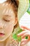 Close-up portrait of a girl in a straw hat enjoying the summer sun with her eyes closed. A pattern of shadows falling on her face