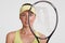 Close up portrait of good looking self determined tennis player looks through racket, has healthy clean skin, looks directly at ca