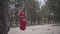 Close up portrait of graceful beautiful young woman in red dress sitting on the swing in the forest and looking an