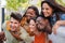 Close up portrait of a group of smiling multiracial teenage friends having fun outdoors. Cherful young people laughing