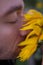 Close up portrait of a guy with shut eyes and sunflower.
