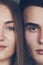 Close up portrait of half faces man and woman looking at camera