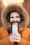 Close-up portrait handsome bearded millennial man in winter clothes and with thermos snow outdoor. Cold season and hot