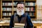 Close up portrait of handsome bearded senior academic professor or library worker, smiling and holding old books, while