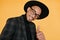 Close-up portrait of handsome black man with charming smile. Studio shot of well-dressed african guy wears hat and