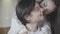 Close-up portrait of handsome Caucasian young man with woman hugging and kissing him. Relaxed millennial boyfriend