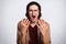 Close up portrait of handsome teenager with curly hair keeps both hands up, stands with open mouth like shout something, dressed