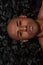 Close up portrait of handsome young african american man looking at camera, posing isolated over black charcoal