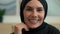 Close up portrait happy Arabian muslim Islamic woman in black hijab indoors cheerful smiling female face dental toothy