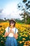 Close up portrait of happy and beautiful young woman relaxing enjoying the fresh beauty of gorgeous orange marigold