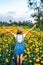 Close up portrait of happy and beautiful young woman relaxing enjoying the fresh beauty of gorgeous orange marigold