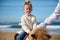 Close-up portrait of happy child girl riding a horse pony on the beach, smiling looking at camera