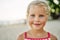 Close up portrait of happy cute little girl. Smiling blonde child on summer