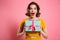 Close-up portrait of happy exited pretty brunette woman holding