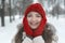 Close-up portrait of happy girl in red hat enjoying winter moments. Happy young woman on snow-covered park background