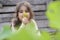 Close up portrait of a happy little girl in garden picking up and smelling some yellow flowers