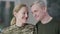 Close-up portrait of happy loving female soldier and smiling man looking at each other, turning to camera and smiling