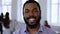 Close-up portrait of happy positive smiling African manager businessman with beard at modern office. Healthy workplace.