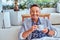 Close-up portrait of a happy rich stylish man dressed in modern elegant clothes holds a cup of coffee at the outdoor