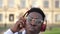 Close-up portrait of happy satisfied African American man in headphones dancing in slow motion looking at camera