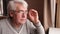 Close-up portrait of happy senior man looking at window. Senior grey-haired man. Retired elderly man sitting at home near window.