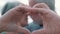 Close up portrait happy sincere middle aged elderly retired family couple making heart gesture with fingers, showing love or