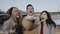 Close up portrait of happy three friends launching drone, quadcopter into sky and watching it fly outdoors. Teenagers