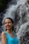 Close up portrait of happy woman at waterfall. Smiling Caucasian woman. Travel lifestyle. Jembong waterfall, Bali, Indonesia