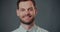 Close-up portrait of happy young smiling Caucasian businessman, coach looking at camera isolated at gray background.