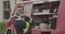 Close-up portrait of heroic fireman in protective suit and holds saved cat in his arms. Firefighter in fire fighting or