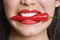 Close-up portrait of Hispanic woman biting red pepper