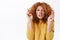 Close-up portrait hopeful, worried cute redhead curly woman in yellow sweater, stooping and grimacing with closed eyes