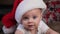 Close up portrait of infant boy wearing Santa hat.