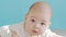 Close-up portrait a infant girl. The face of a Caucasian little girl lying on the bed. baby 6 mounth looking in camera.