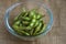 Close up portrait of Japanese food edamame nibbles, boiled green soybeans