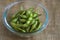 Close up portrait of Japanese food edamame nibbles, boiled green soybeans