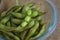 Close up portrait of Japanese food edamame nibbles, boiled green soybeans