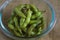 Close up portrait of Japanese food edamame nibbles, boiled green soybeans