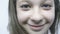 Close-up portrait of a joyful young girl. A beautiful girl with big eyes is standing in the wind in slowmo.