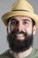Close up portrait of laughing bearded man in straw hat looking at camera.