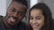 Close-up portrait of laughing joyful African American teen daughter and father posing indoors at home on weekend