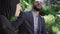 Close-up portrait of laughing Middle Eastern bearded man and muslim woman in hijab resting on bench in sunny summer park