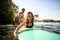 Close-up portrait of laughing woman lies on surfboard and rows her hands and male instructor supports her