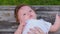 Close-up portrait of a little beautiful half year old girl in white bodysuit