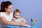 Close up portrait of little Caucasian boy sitting at table and drawing picture by colour pencil witg his mummy, mother teach her