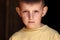 close up portrait of little child. kid boy outdoors looking in camera. Face Eyes Serious Contemplative Child.