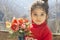 Close up portrait of a little girl holding an artificial flower vase by hand