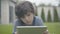 Close-up portrait of lonely boy using tablet outdoors. Unhappy Caucasian schoolboy spending weekends alone at home. Sad
