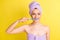 Close-up portrait of lovely naked girl wearing turban cleansing teeth isolated over vibrant yellow color background