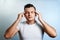 Close-up portrait of a man, covering his face with his hands. On a light background. The concept of body language